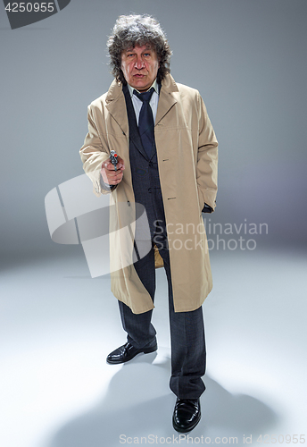 Image of Senior police agent with a gun on dark smoke background