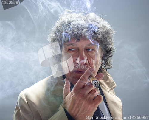 Image of The senior man with cigar as detective or boss of mafia on gray studio background