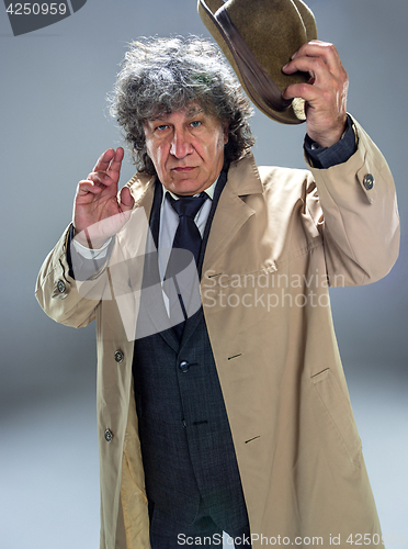 Image of The senior man as detective or boss of mafia on gray studio background