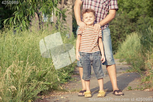 Image of Father and son playing at the park at the day time.