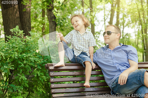 Image of Father and son playing at the park at the day time.