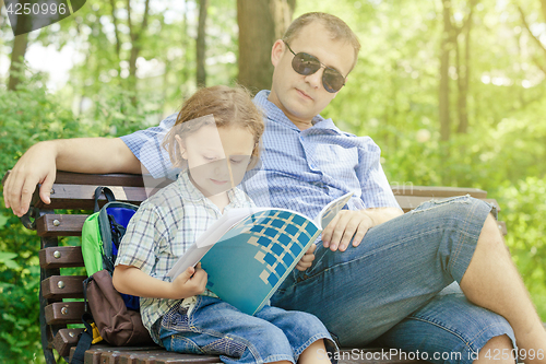 Image of Father and son playing at the park at the day time.