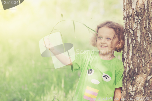 Image of Cute little boy  playing with flowers in  park