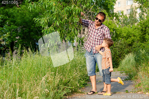 Image of Father and son playing at the park at the day time.