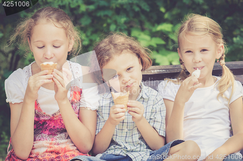 Image of Three happy children  playing in the park at the day time.