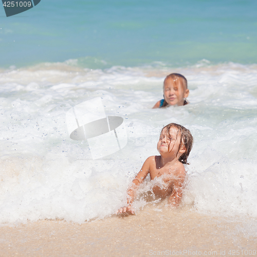 Image of Sister and brother playing on the beach at the day time.