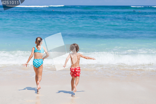 Image of Sister and brother playing on the beach at the day time.