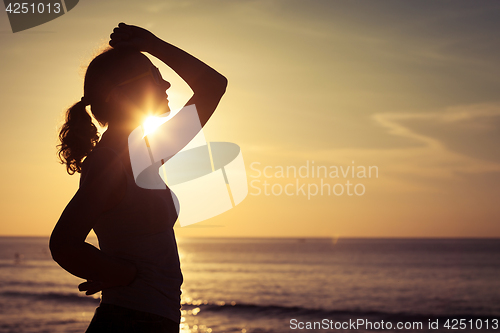 Image of woman open arms under the sunrise at sea