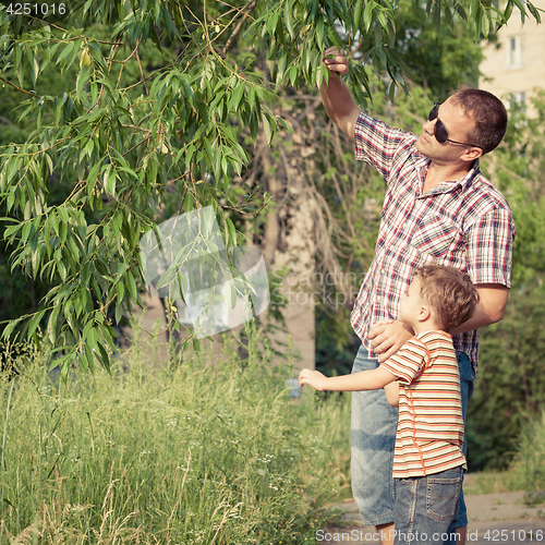 Image of Father and son playing at the park at the day time.