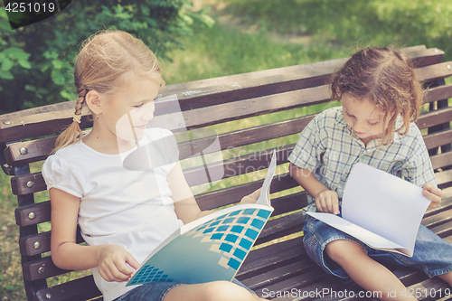 Image of Three happy children  playing in park