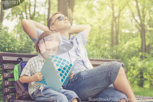 Image of Father and son playing at the park at the day time.