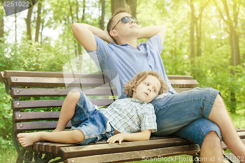 Image of Father and son playing at the park at the day time.