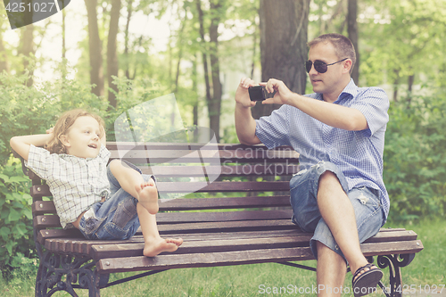 Image of Father and son playing at the park at the day time.