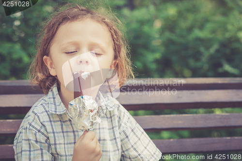 Image of little boy eating ice cream in the park