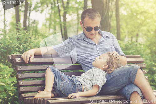 Image of Father and son playing at the park at the day time.