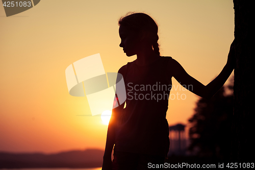 Image of Portrait of sad blond little girl standing on the beach