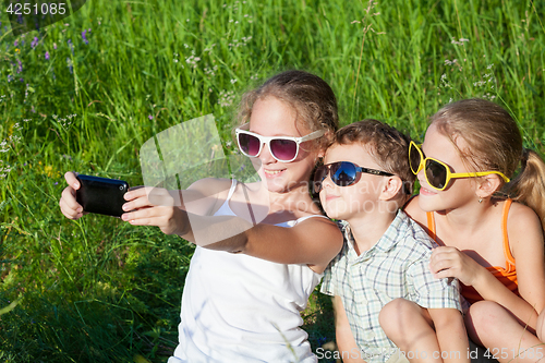 Image of Three happy children  playing in the park at the day time.