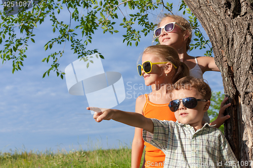 Image of Three happy children  playing in the park at the day time.