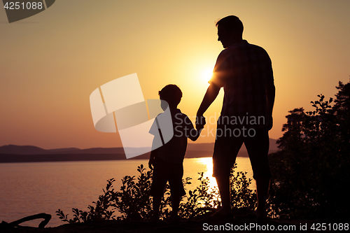 Image of father and son playing on the coast of lake