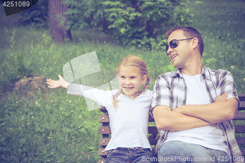 Image of Father and daughter playing at the park at the day time.