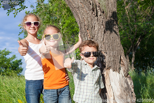 Image of Three happy children  playing in the park at the day time.