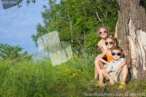 Image of Three happy children  playing in the park at the day time.