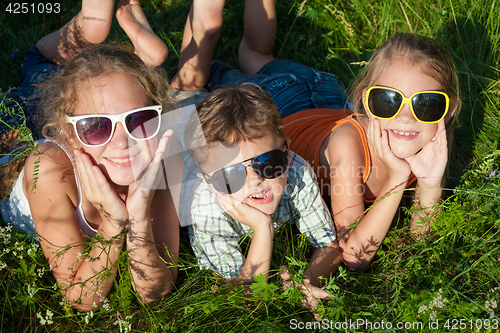 Image of Three happy children  playing in the park at the day time.