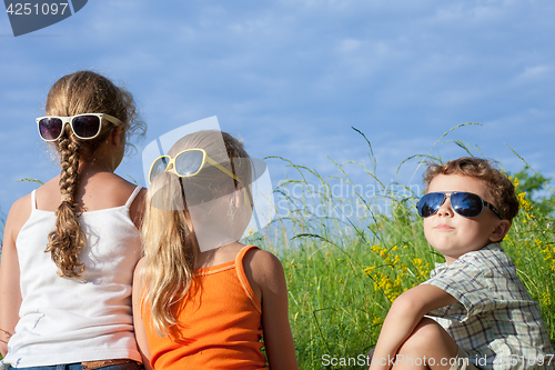 Image of Three happy children  playing in the park at the day time.