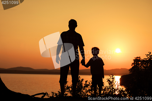 Image of father and son playing on the coast of lake