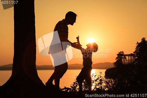 Image of father and son playing on the coast of lake