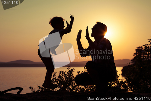 Image of father and son playing on the coast of lake