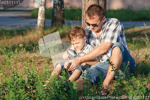 Image of Father and son playing at the park at the day time.