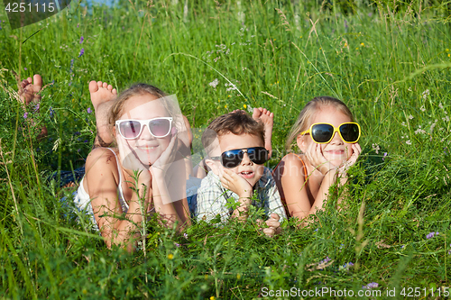 Image of Three happy children  playing in the park at the day time.