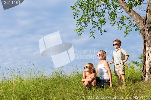 Image of Three happy children  playing in the park at the day time.