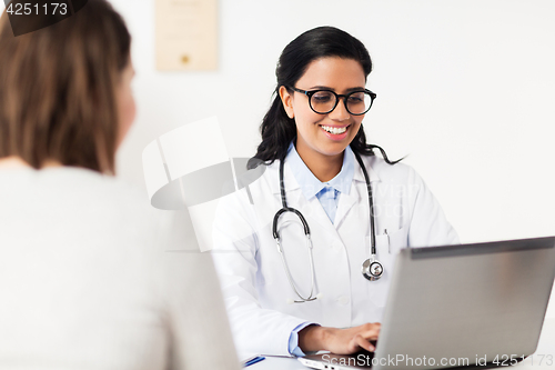 Image of doctor with laptop and woman patient at hospital