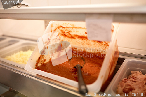 Image of container with tomato sauce at restaurant kitchen