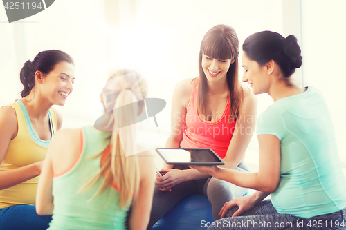 Image of happy pregnant women with gadgets in gym