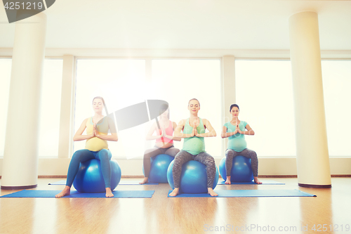 Image of happy pregnant women exercising on fitball in gym