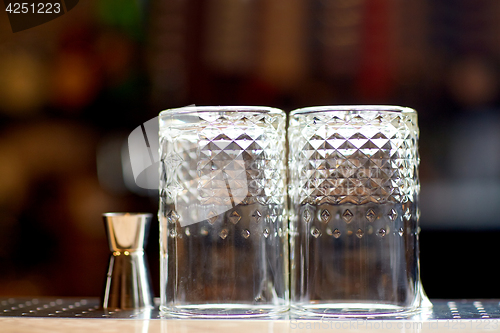 Image of two vintage glasses and jigger on bar counter