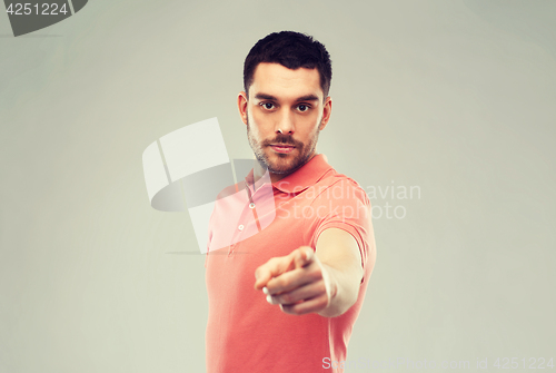 Image of angry man pointing finger to you over gray