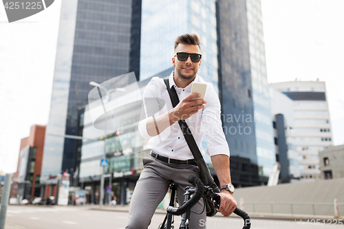 Image of man with bicycle and smartphone on city street