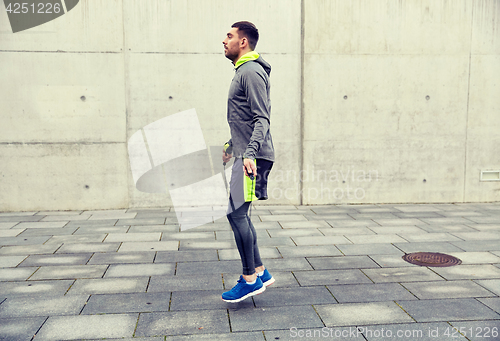 Image of man exercising with jump-rope outdoors