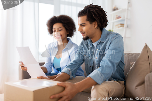 Image of happy couple with parcel box and paper form home