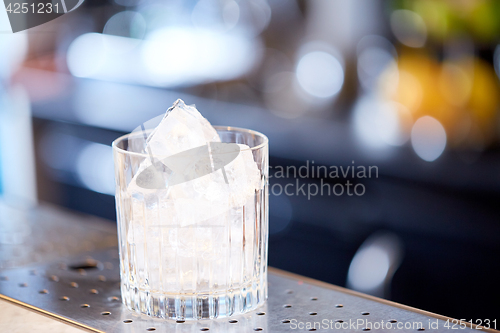 Image of glass with ice cubes at cocktail bar