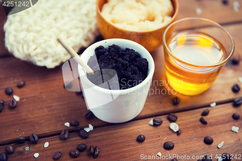 Image of close up of coffee scrub in cup and honey on wood