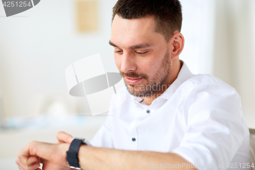 Image of close up of businessman with smartwatch at office