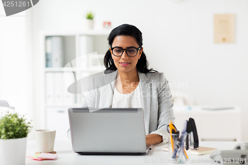 Image of happy smiling businesswoman with laptop at office