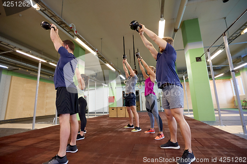 Image of group of people with kettlebells exercising in gym