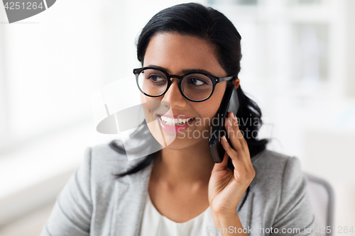 Image of businesswoman calling on smartphone at office