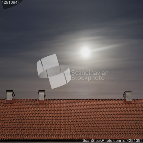 Image of tiled top of the roof, cloudy blue sky